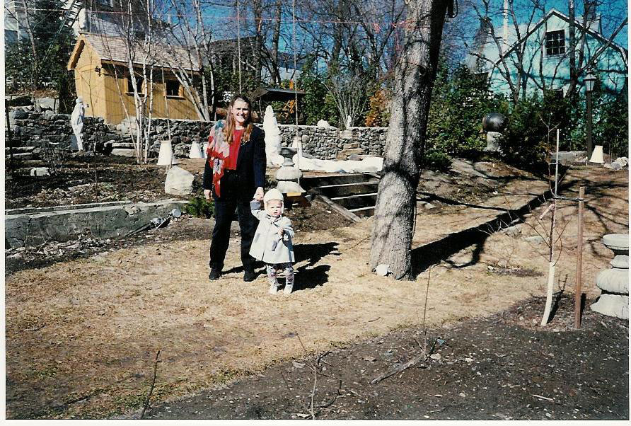 Une descendante maternelle de la famille Pigeon et amie de Rolland lui rendant visite au printemps 1996. Le Gazébo n’y était pas et le gros frêne, juste à leur gauche, n’y est plus puisqu’il menaçait la culture au sol par son ombre dense. La topographie du site contribue à créer le mouvement des jardins.